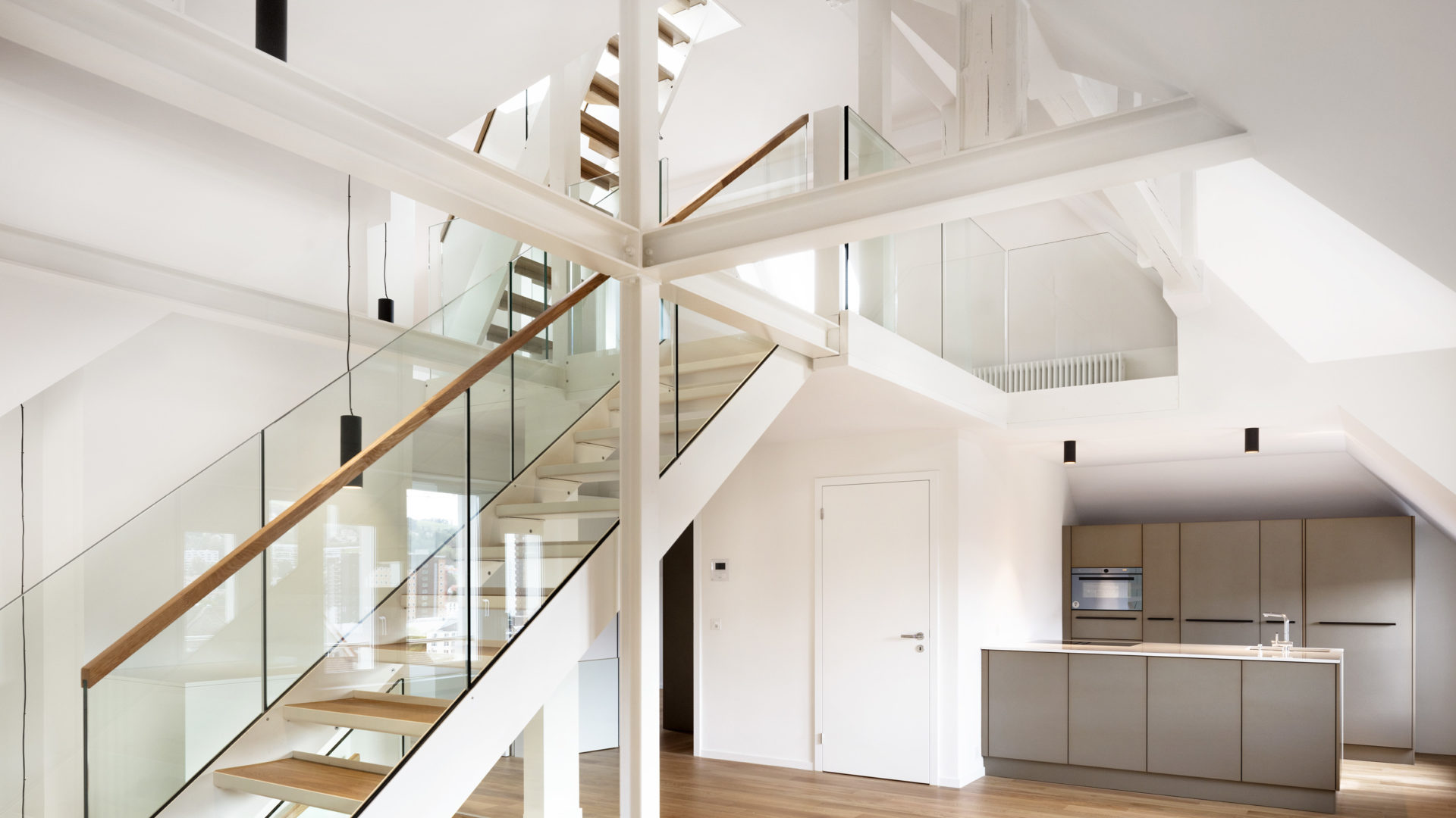 Viel Glas und weisse Treppen machen einen modernen Eindruck.