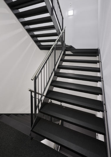 In einem Treppenhaus mit Brandschutzvorschriften eignen sich auch Stahlwangentreppen mit Granitstufen.